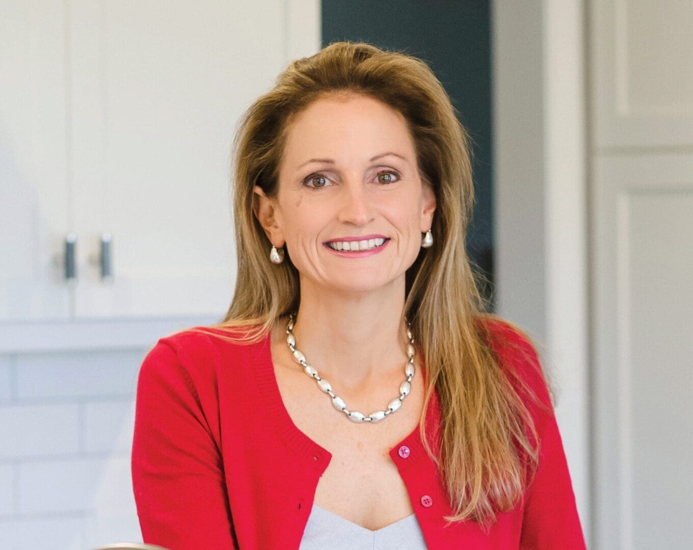A woman in red jacket smiling for the camera.