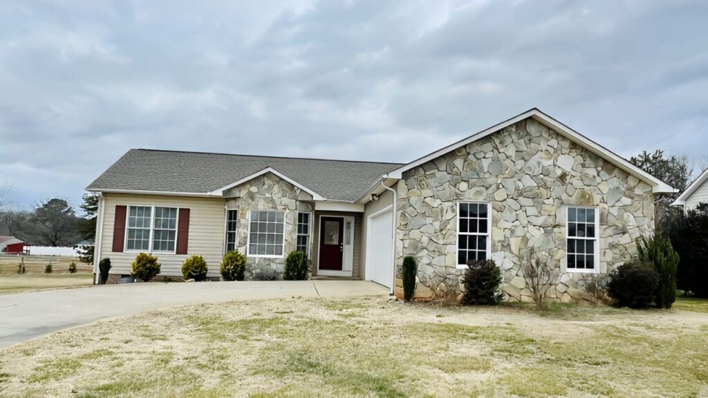 A house with a garage and stone walls.