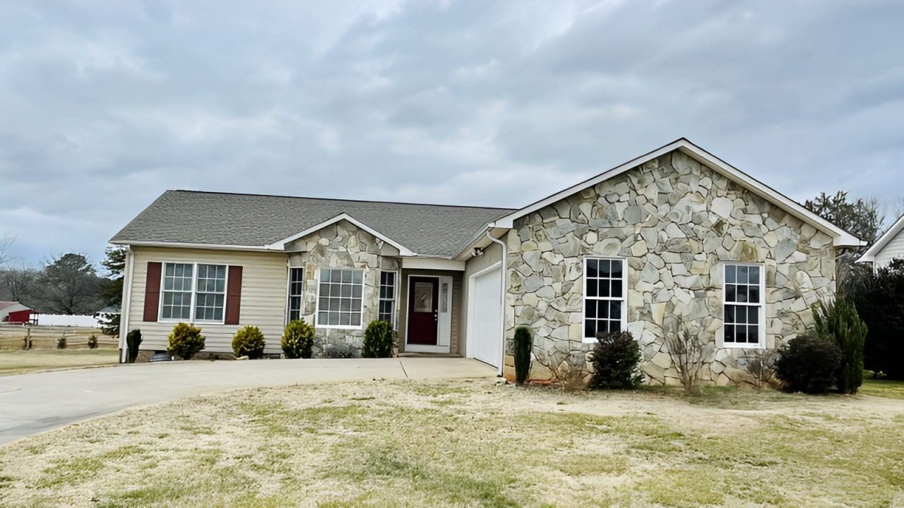 A house with a garage and stone walls.