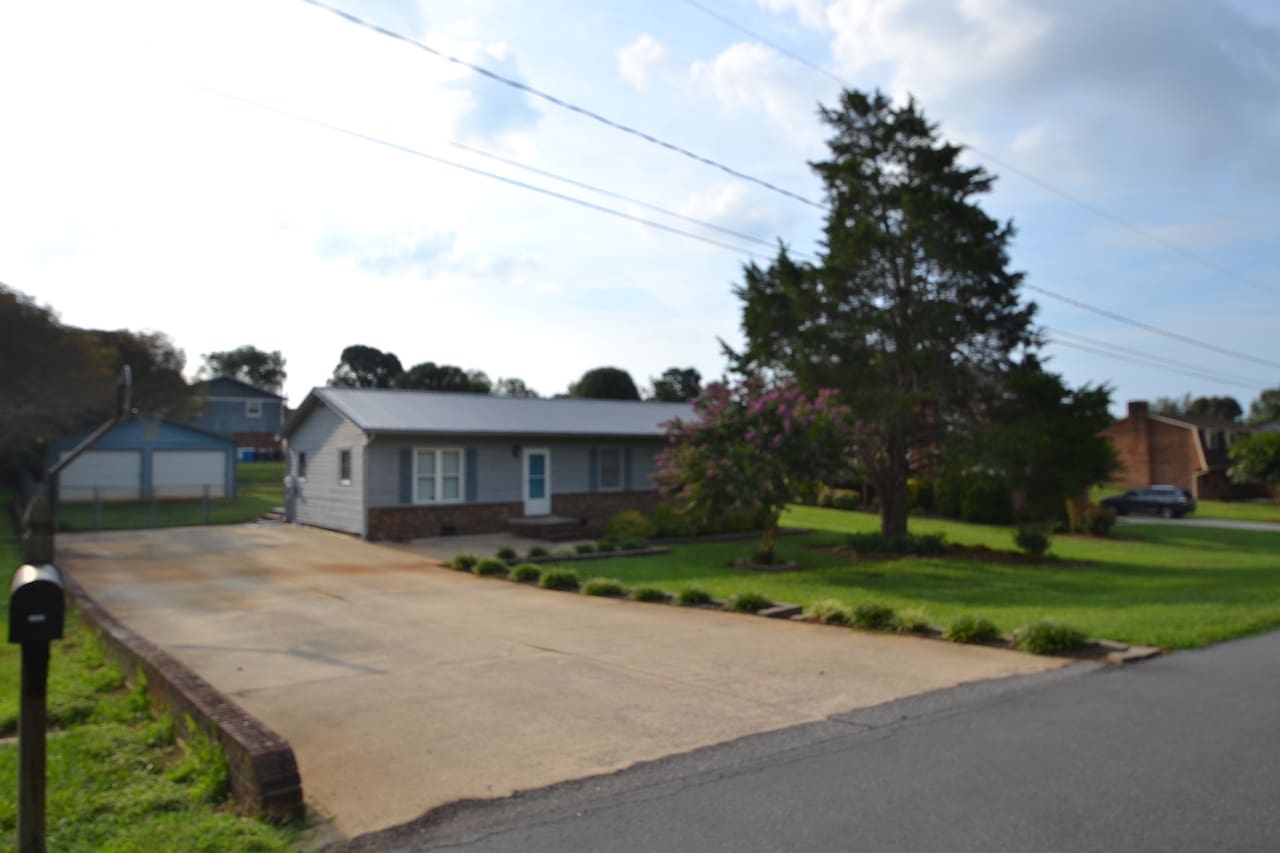 Single-story house with driveway and large tree