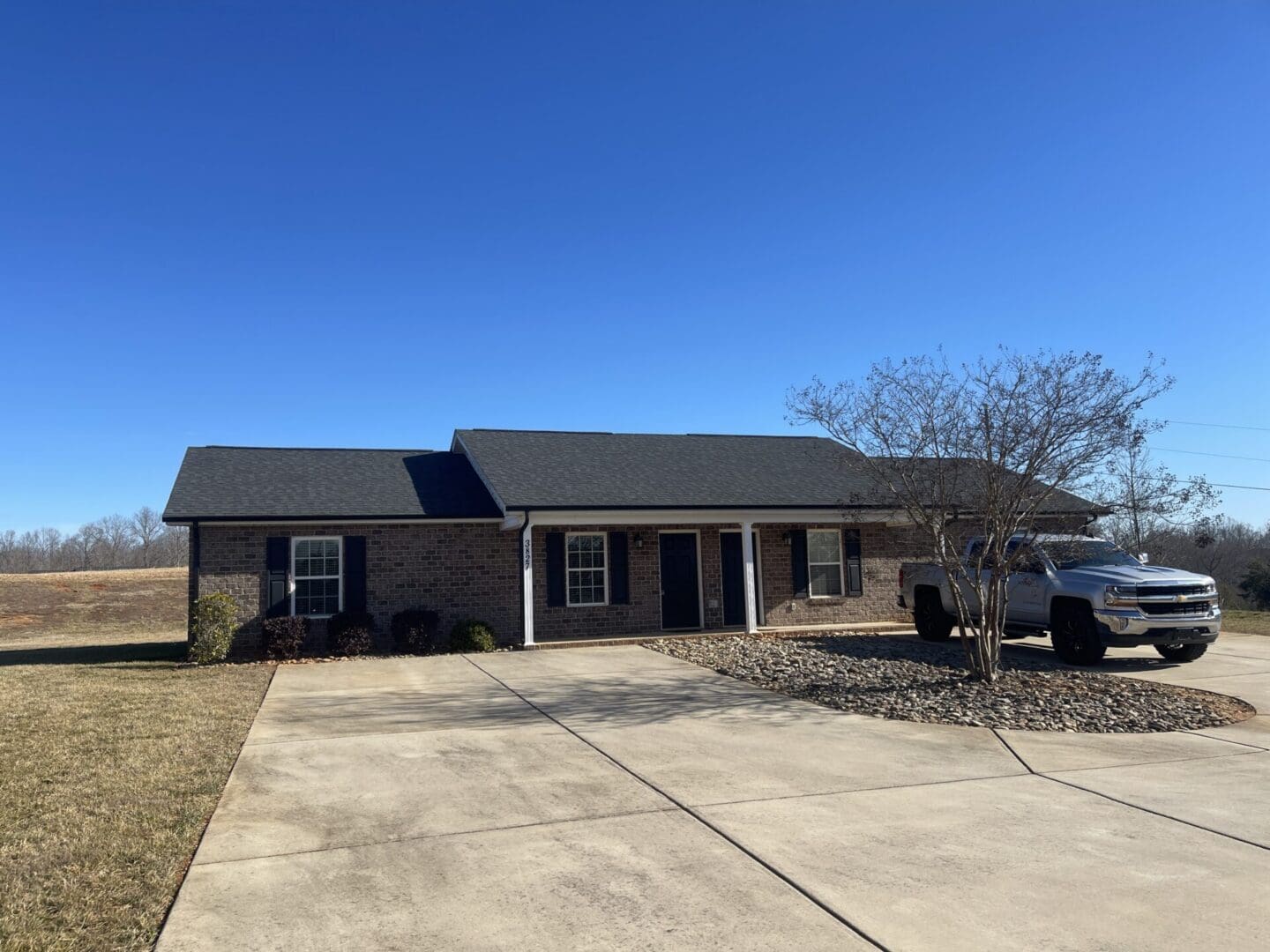 Single-story brick home with gravel landscaping.